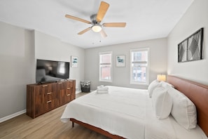 A bedroom with a bed, a TV, a ceiling fan, and a window. - Short North 2br, 2 Kings and Free Parking (Columbus)