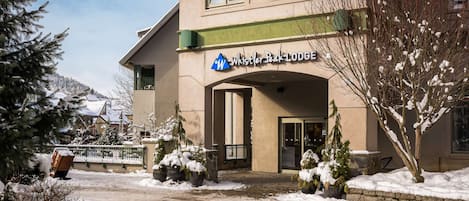 Un bâtiment sur lequel on peut lire l’inscription « Whistler Peak Lodge », et dont l’entrée est recouverte de neige.