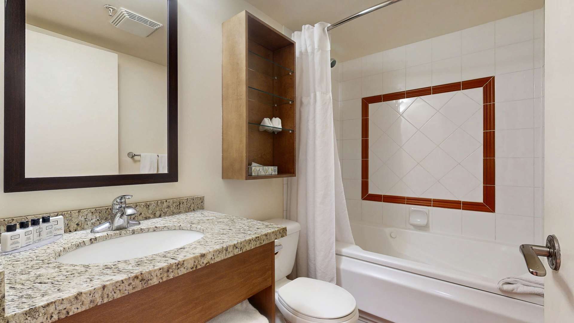 Une salle de bain avec un meuble-lavabo à deux vasques, des toilettes, une baignoire et un rideau de douche.