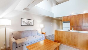 A modern living room with a sofa, a coffee table, a lamp, and a framed picture on the wall. - Whistler - Whistler Peak Lodge 612 (Whistler)