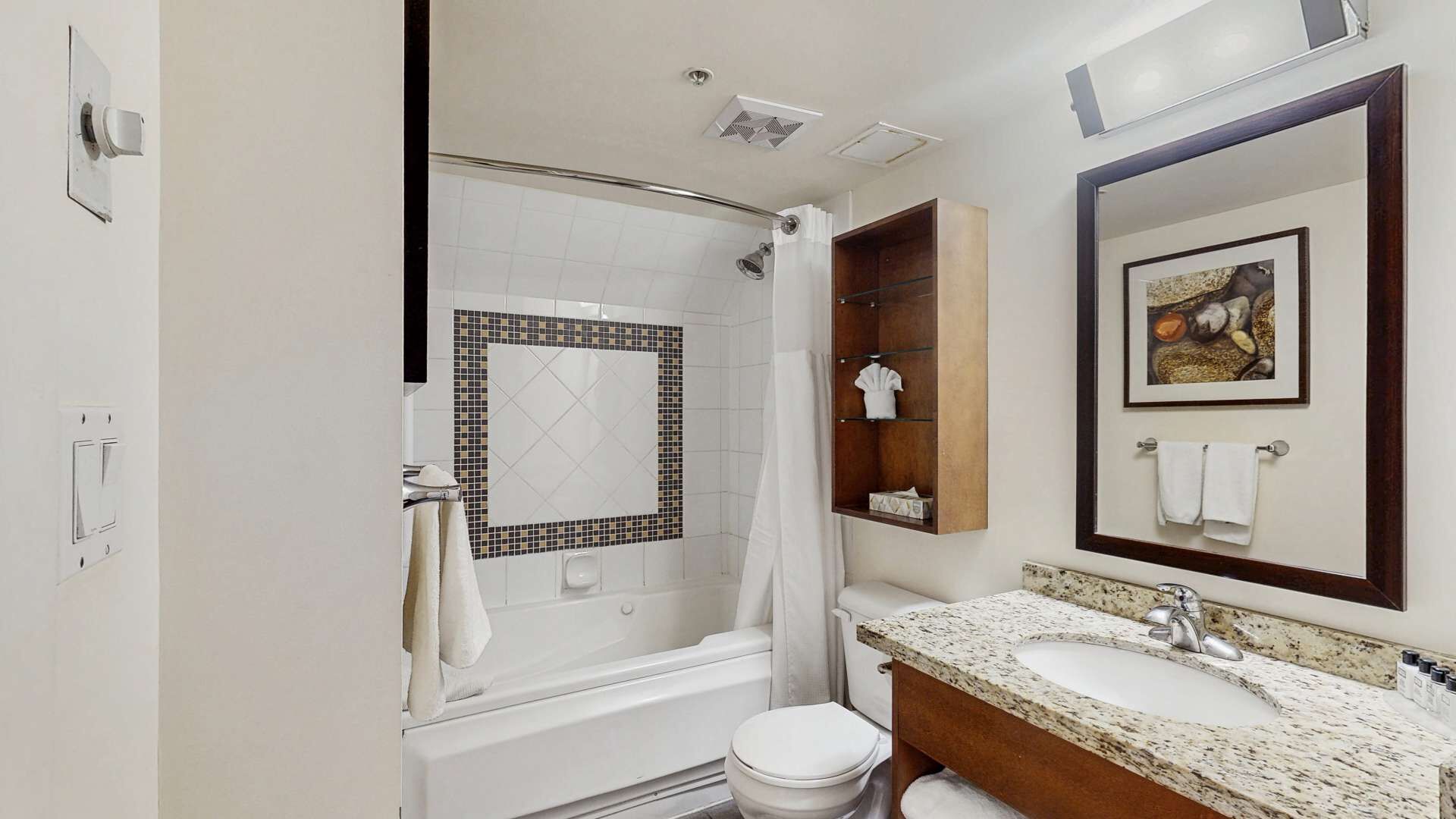 Une salle de bain équipée d’une douche, d’un lavabo, de toilettes, d’un miroir et d’un porte-serviettes.