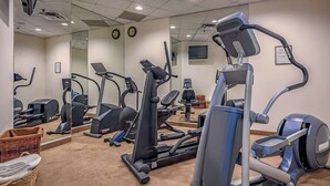 A gym with various cardio machines, a mirrored wall, and a clock. - Whistler - Whistler Peak Lodge 619 (Whistler)