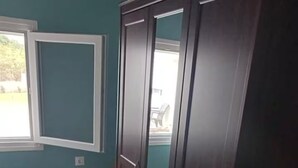 A room with teal walls, a wooden wardrobe, a window, and a red chair. - Acheron Flow by ΜΡS (Acherontas)
