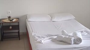 A hotel room with a bed, a nightstand, and a wall-mounted TV. - Acheron Flow by ΜΡS (Acherontas)