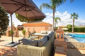 Una piscina al aire libre, sombrillas, tumbonas