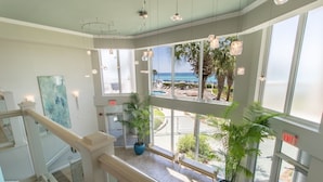 A hotel lobby with a view of the beach, potted plants, and a staircase. - Silver Beach 0306e 3 Bedroom Condo (Destin)