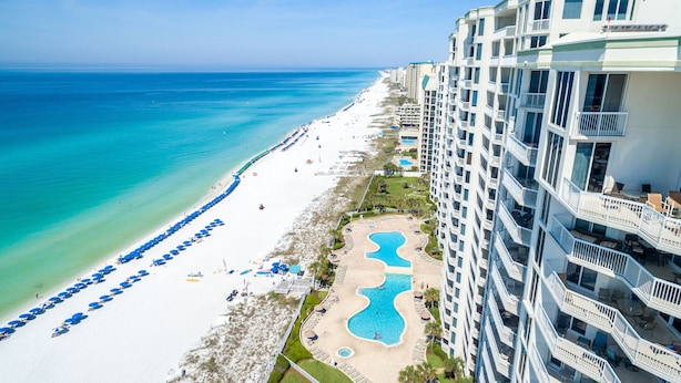 A beachfront hotel with a pool, beach umbrellas, and a view of the ocean. - Silver Beach 0306e 3 Bedroom Condo (Destin)
