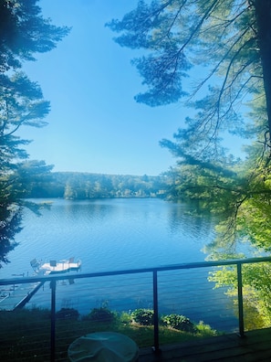 Une vue sur le lac, avec un bateau amarré près du rivage, entouré d’arbres et sous un ciel dégagé.