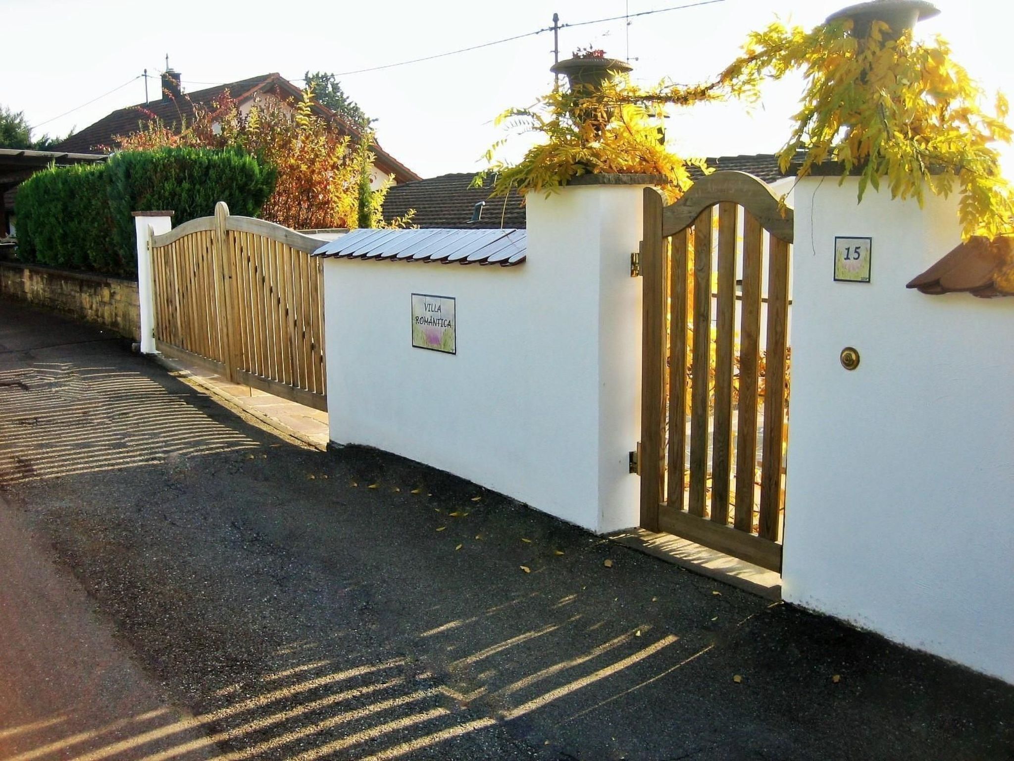 A gated entrance with a sign reading "Villa Romantica" and a number "15" on the wall.