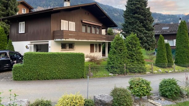 A two-story house with a balcony, surrounded by greenery and mountains in the background. - Lungern by Interhome (Bürglen OW)