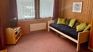 A cozy room with a wooden bunk bed, a small desk with a television, and a window with curtains. - Lungern by Interhome (Bürglen OW)