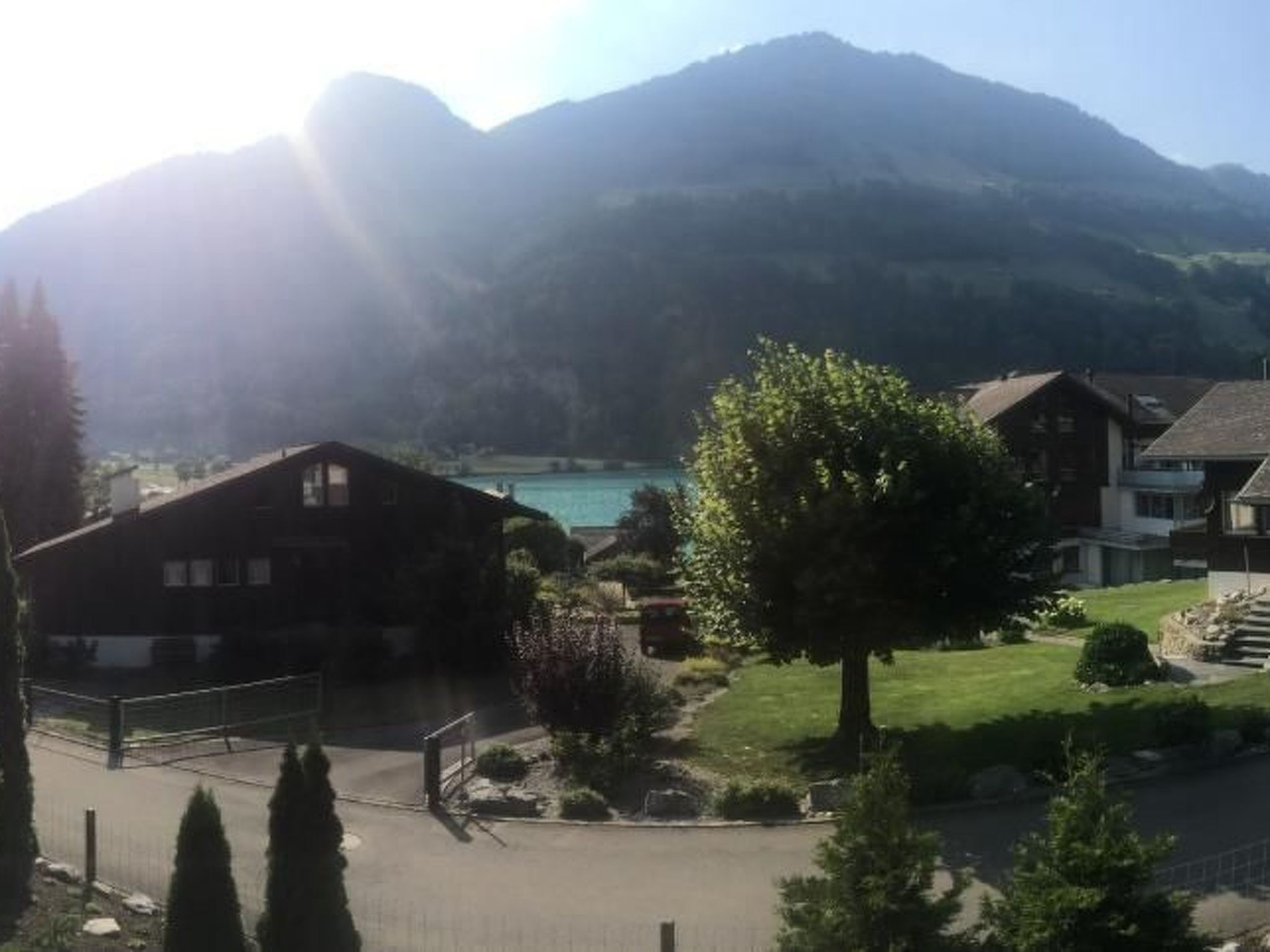 A residential area with houses, a tree, and mountains in the background.