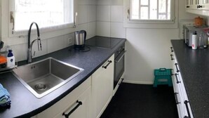 A kitchen with a sink, stove, and a window with blinds. - Lungern by Interhome (Bürglen OW)