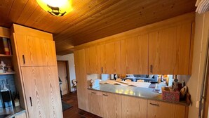 Een moderne keuken met houten kastjes, een centraal eiland en een inbouwoven.