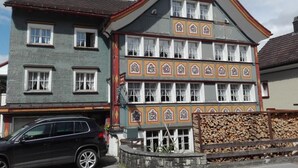 A two-story building with a traditional architectural style, featuring a steeply pitched roof and decorative trim. - Blaues Haus by Interhome (Appenzell)