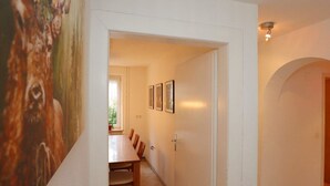 A hallway with a dining area, a door, and a wall with framed pictures. - Bertsche 3 Schlafzimmer by Interhome (Rietheim)