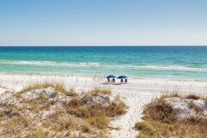 A beach with two blue umbrellas and a sandy path leading to the water. - Sandy Shores, Beach, Pool, Golf Cart, Fire Pit, Tennis (Destin)