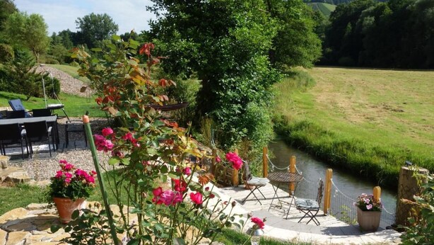 A garden patio with a stone pathway, a small water feature, and outdoor seating. - Tolle Wohnung in Klüsserath mit Großem Garten by Interhome (Klüsserath)