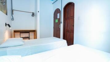 Una habitación con dos camas, un armario de madera y dos puertas de madera.