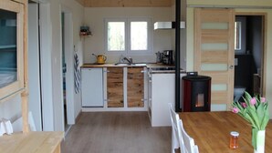 Una cucina compatta con mobili in legno, un piano cottura integrato e una finestra che offre luce naturale.