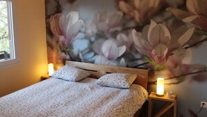 Una camera da letto con un letto, decorazioni murali a fiori e lampade da comodino.