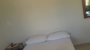 Cama bem arrumada com lençóis e toalhas brancas.