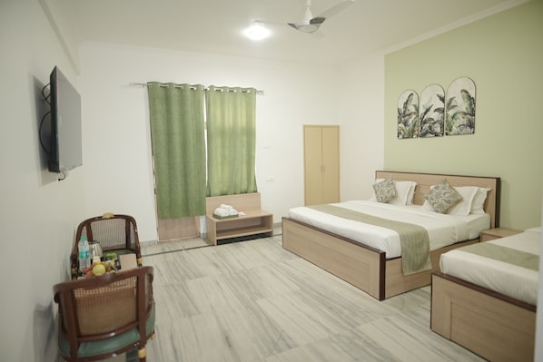 A hotel room with a bed, a chair, a desk, and a wardrobe. - Shri Thakur Ji Niketan Near ISKCON (Vrindavan)