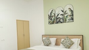 A bedroom with a wooden bed, a wardrobe, and a wall-mounted artwork. - Shri Thakur Ji Niketan Near ISKCON  (Vrindavan)