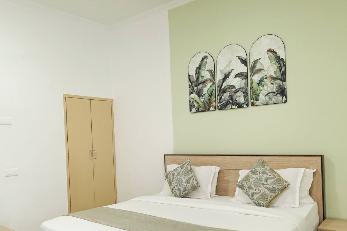 Une chambre à coucher avec un lit en bois, une armoire et une œuvre d’art accrochée au mur.
