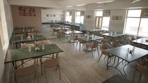 A classroom with tables and chairs, large windows, and educational posters on the walls. - Shri Thakur Ji Niketan Near ISKCON  (Vrindavan)