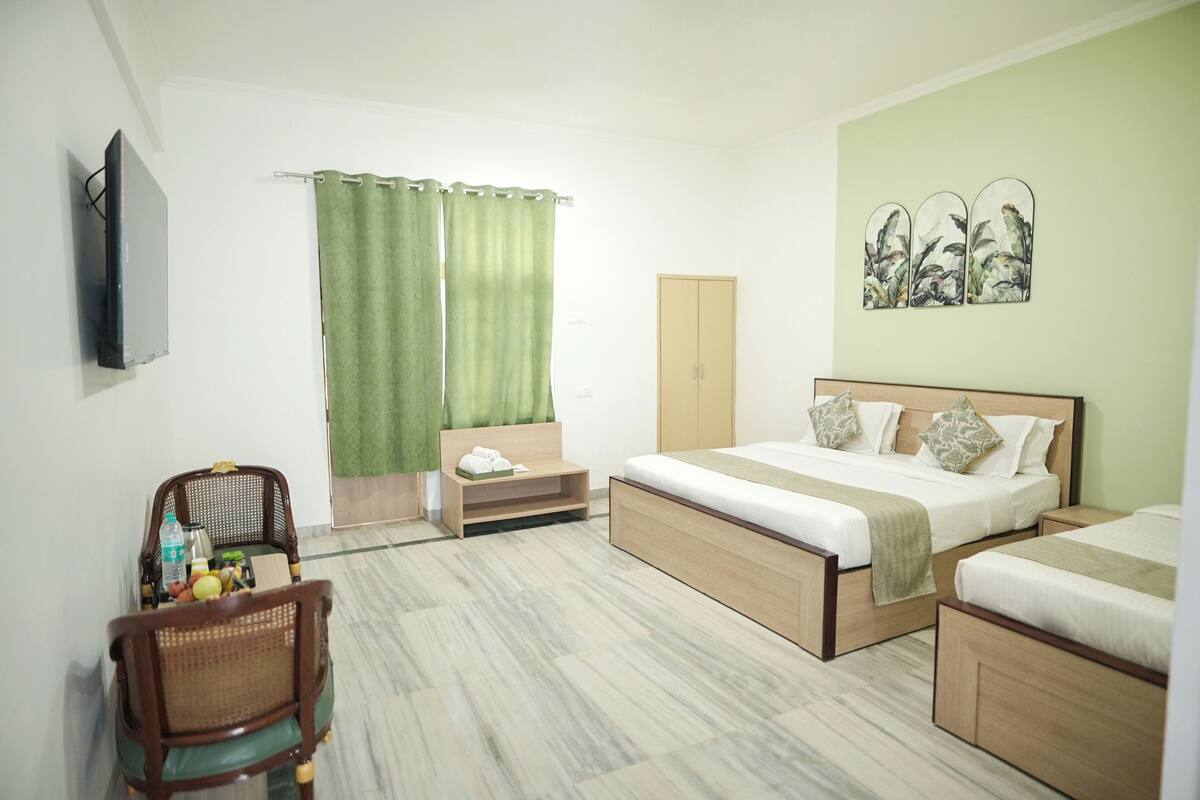 Une chambre d’hôtel avec un lit, une chaise, un bureau, une armoire et un tableau au mur.