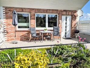 A patio with a table and chairs, a brick wall, and a satellite dish. - Ferienhaus direkt am Wasser by Interhome (Stralsund)