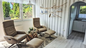 A modern living room with two leather chairs, a small coffee table, and a view of the outdoors. - Ferienhaus direkt am Wasser by Interhome (Stralsund)