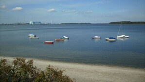 A calm body of water with several small boats anchored near the shore. - Ferienhaus direkt am Wasser by Interhome (Stralsund)