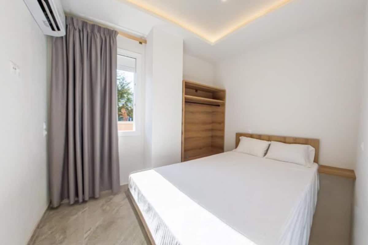 Une chambre à coucher comprenant un lit, une armoire et un appareil de climatisation.