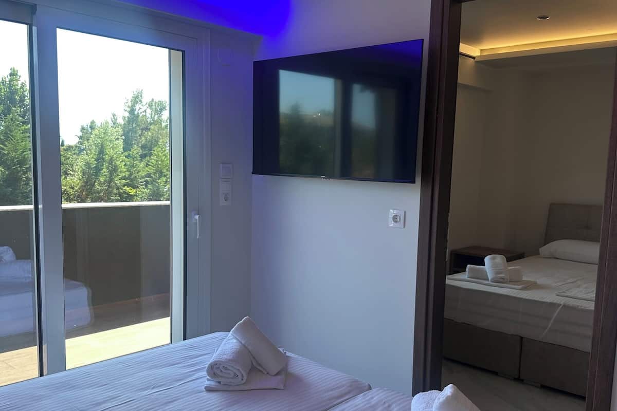Une chambre d’hôtel avec deux lits, une télévision et un balcon.