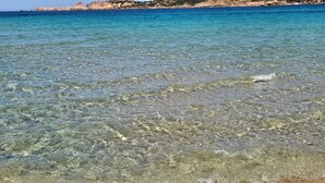 Clear shallow waters with visible seabed and rocky coastline. - Calarossa-Red Island First Row House with Sea View and Double Terrace (Trinità d'Agultu e Vignola)