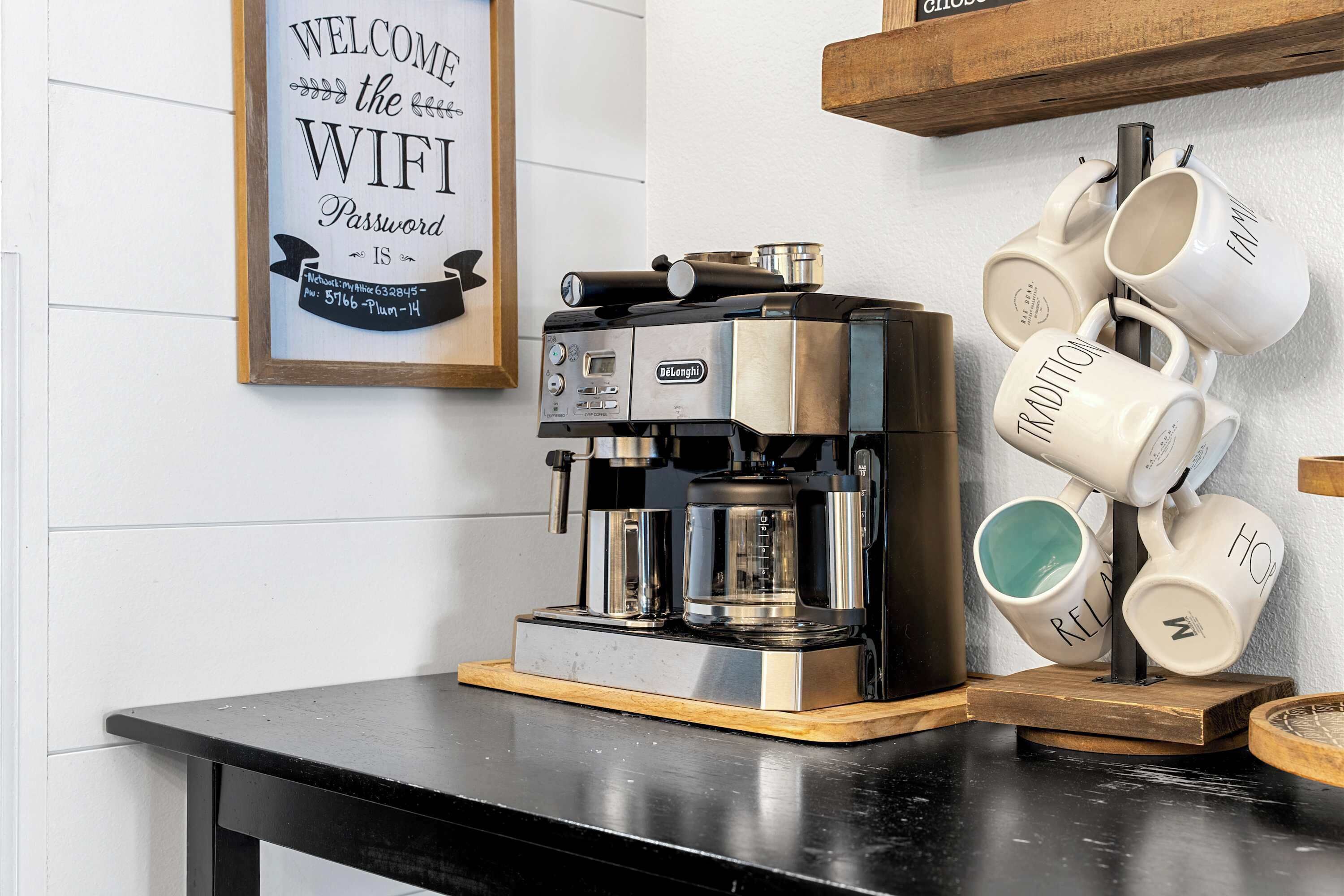 A coffee machine on a counter with a framed sign above it.