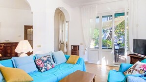 A living room with a blue sofa set, a wooden coffee table, and a TV on a stand.
