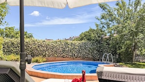 Zona de piscina con pileta, sillas de descanso y una botella de champán.