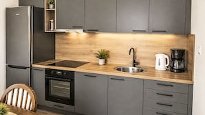 Una cocina moderna con horno integrado, lavaplatos y cafetera.