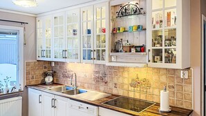 A modern kitchen with white cabinets, a double sink, and a wooden countertop. - Villa Daniel by Interhome (Storebro)
