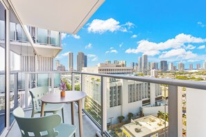Ein Balkon mit Tisch und Stühlen und Blick auf die Stadt.