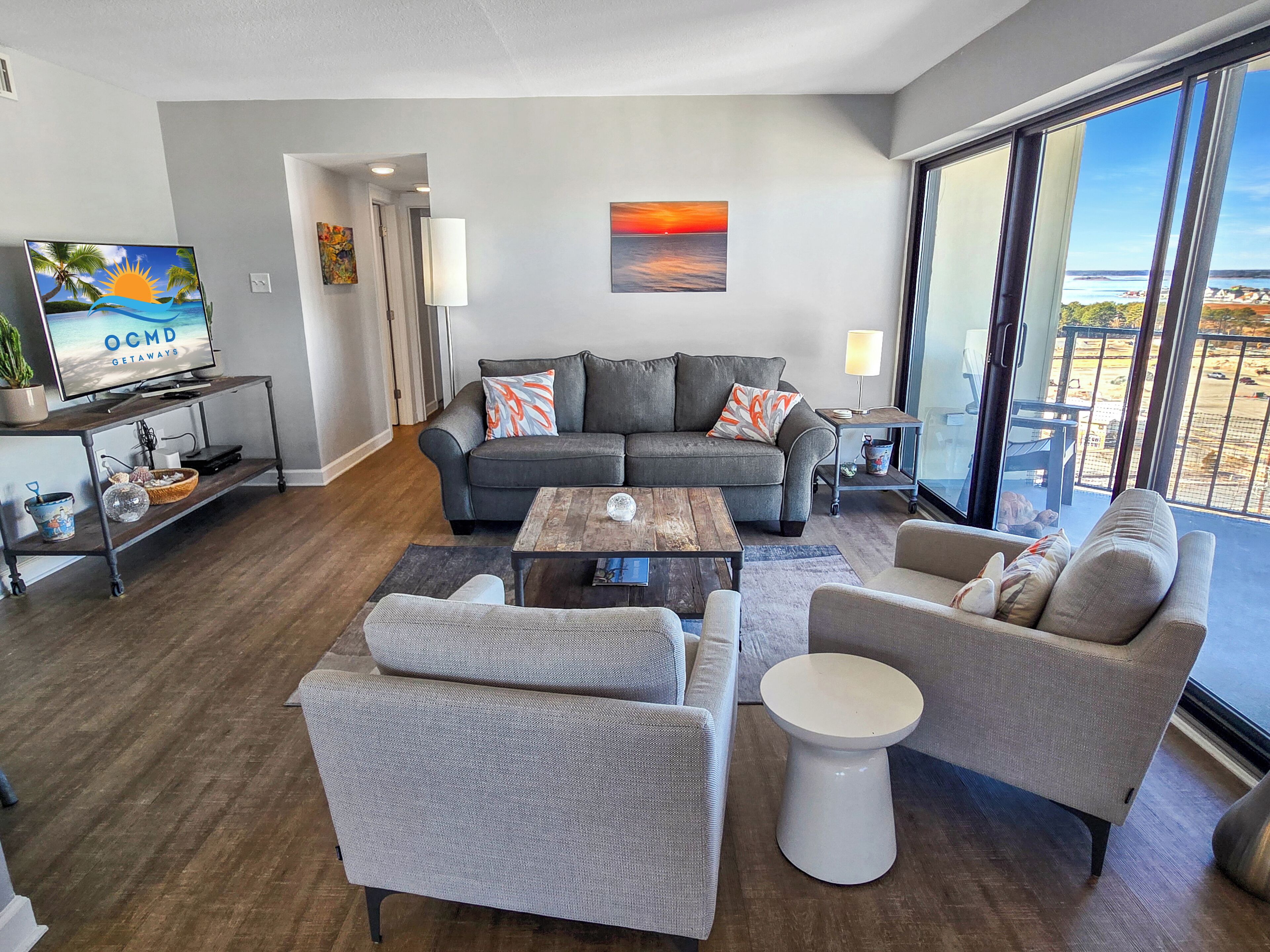 A modern living room with a grey sofa, a coffee table, and a TV on a stand.