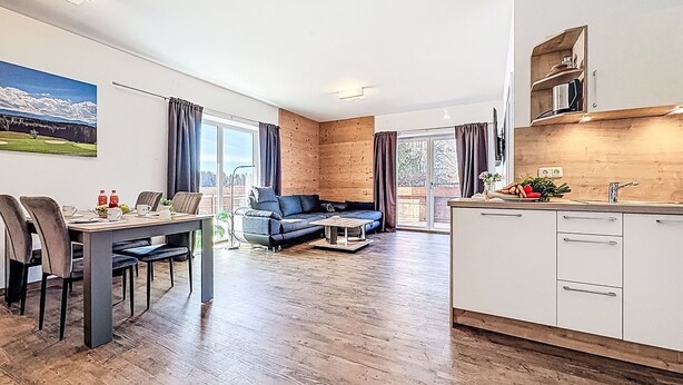 Eine moderne Wohnung mit Essbereich, einer Couch und einer Küche.