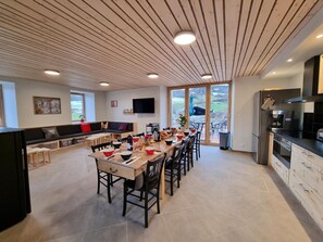 Una cocina moderna con comedor, ventanas amplias y vistas al exterior.