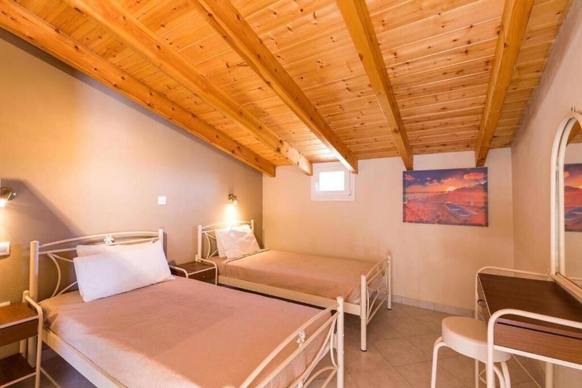 A bedroom with two single beds, a desk, and a chair.