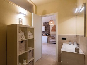 Ein Badezimmer mit einem weißen Waschbecken, einem Spiegel und einem Handtuchhalter.