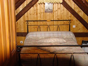 Ein Schlafzimmer im Loft-Stil mit Holzbalken, einem Bett und einem Schild mit der Aufschrift Paris.