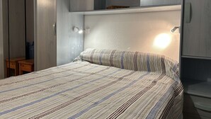 A bedroom with a bed, built-in wardrobe, and bedside lamps. - Seaside house 3 rooms, terrace, pets allowed (Fleury-Saint-Pierre-la-Mer)